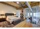 Spacious main bedroom with a plush bed, tufted ottoman, and hardwood floors at 260 18Th Nw St # 10302, Atlanta, GA 30363