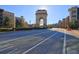 Sun-drenched road leading to a historic arch, lined with trees and modern buildings at 260 18Th Nw St # 10302, Atlanta, GA 30363