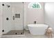 Elegant bathroom featuring a soaking tub, glass shower with marble tile, and modern fixtures at 3637 Green Pine Way, Suwanee, GA 30024