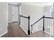 Hallway with hardwood floors and stairs with dark stained handrail and white posts at 3637 Green Pine Way, Suwanee, GA 30024