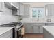 This modern kitchen provides gray cabinets, white countertops, and stainless steel appliances at 3637 Green Pine Way, Suwanee, GA 30024