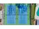Overhead shot of community tennis courts with nets and shadow from trees on blue and green surface at 3637 Green Pine Way, Suwanee, GA 30024