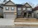 Charming two-story home featuring a mix of stone and siding, with a two-car garage and manicured front yard at 5215 Tye Trl, Fairburn, GA 30213