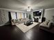 Comfortable living room featuring a large sectional sofa, fireplace, ceiling fan, and dark hardwood floors at 5215 Tye Trl, Fairburn, GA 30213