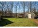 Backyard view showcases the lush lawn, shed, and mature trees at 1312 La Mesa Dr, Lawrenceville, GA 30043
