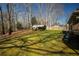 A spacious backyard showcasing the verdant lawn, shed, and mature trees at 1312 La Mesa Dr, Lawrenceville, GA 30043