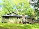 Back exterior of home with an expansive lawn, stone chimney, and wooden deck at 1312 La Mesa Dr, Lawrenceville, GA 30043