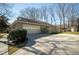Side view of home showing a detached garage with paved driveway and storage shed in the backyard at 1312 La Mesa Dr, Lawrenceville, GA 30043