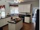 Well-lit kitchen with an island cooktop and ample counter space and white cabinets at 1470 Sweet Bottom Sw Cir, Marietta, GA 30064