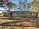 Backyard is covered in leaves, and shows the back of the house with multiple windows at 1894 Dogwood Ct, Snellville, GA 30078