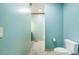 Bright bathroom with a toilet and tile flooring, leading to a vanity area with blue walls at 3192 Highway 411 Ne, White, GA 30184