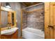 Rustic bathroom with a vessel sink, wooden mirror, and a soaking tub with modern showerhead at 3192 Highway 411 Ne, White, GA 30184