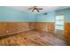 A bedroom with a wood paneled wainscoting, hardwood flooring, and a ceiling fan at 3192 Highway 411 Ne, White, GA 30184