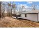 White cottage with a screened-in porch and a metal roof with trees surrounding the property at 3192 Highway 411 Ne, White, GA 30184