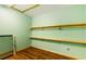 A bright walk-in closet with wood shelving and hanging rods and wood-look flooring at 3192 Highway 411 Ne, White, GA 30184