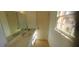 Bright bathroom featuring a large mirror, neutral stone countertop, and a window providing natural light at 3307 York Pl, Decatur, GA 30032