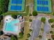 Aerial view of community pool, tennis courts, parking area, and other amenities surrounded by trees at 4590 Gablestone Xing, Hoschton, GA 30548