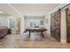 Finished basement boasts a pool table with rustic sliding barn doors and hardwood floors at 4590 Gablestone Xing, Hoschton, GA 30548