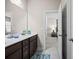 Modern bathroom featuring a double vanity and an open doorway leading to a bright bedroom at 4590 Gablestone Xing, Hoschton, GA 30548