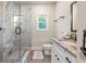 Bathroom boasts marble-style tile shower, granite vanity, and hardwood-style floors at 4590 Gablestone Xing, Hoschton, GA 30548