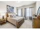 Bedroom with a full-sized bed, two windows, and two artistic pictures hung on the wall at 4590 Gablestone Xing, Hoschton, GA 30548