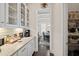 Bright butler's pantry featuring granite countertops, decorative backsplash and shelving with see-through cabinets at 4590 Gablestone Xing, Hoschton, GA 30548