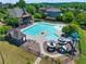 Aerial view of large community pool with a slide, clubhouse, chairs, and covered picnic area at 4590 Gablestone Xing, Hoschton, GA 30548