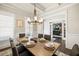 Elegant dining room featuring a coffered ceiling, wainscoting, and a wooden table with seating for six at 4590 Gablestone Xing, Hoschton, GA 30548