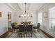 Formal dining room with a decorative chandelier, wainscoting, and a large table for Gathering gatherings at 4590 Gablestone Xing, Hoschton, GA 30548
