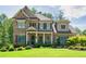Charming two-story home featuring a stone and brick facade, lush green lawn, and well-manicured landscaping at 4590 Gablestone Xing, Hoschton, GA 30548