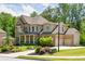 Charming two-story home with a brick facade, three-car garage, and professionally landscaped front yard at 4590 Gablestone Xing, Hoschton, GA 30548