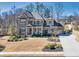 Stunning two-story brick home featuring a well-maintained lawn, lush landscaping, and a charming front entrance at 4590 Gablestone Xing, Hoschton, GA 30548