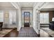 Inviting foyer featuring hardwood floors, crown molding, transom windows, and a decorative area rug at 4590 Gablestone Xing, Hoschton, GA 30548