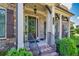Close-up of the inviting front porch, featuring brick steps, a wooden door, and decorative columns at 4590 Gablestone Xing, Hoschton, GA 30548