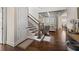 Hallway with staircase featuring dark wood floors, iron railings and an open view to the living room at 4590 Gablestone Xing, Hoschton, GA 30548