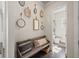 Hallway with a bench, decorative mirrors and views into the half bathroom with stylish decorations at 4590 Gablestone Xing, Hoschton, GA 30548