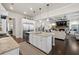 Open-concept kitchen featuring a large island with seating, granite countertops, and modern appliances at 4590 Gablestone Xing, Hoschton, GA 30548