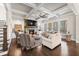 Bright living room boasts coffered ceilings, a stone fireplace, and hardwood floors at 4590 Gablestone Xing, Hoschton, GA 30548