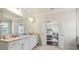 A main bathroom with double vanity sinks and an open door leading to the main bedroom at 4590 Gablestone Xing, Hoschton, GA 30548