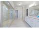 This bathroom features a large glass shower and long vanity with double sinks at 4590 Gablestone Xing, Hoschton, GA 30548