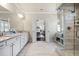 A main bathroom with double vanity sinks, a walk-in shower, and an open door to the main bedroom at 4590 Gablestone Xing, Hoschton, GA 30548