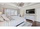 Main bedroom with a ceiling fan, many windows for natural light, and a TV on the wall at 4590 Gablestone Xing, Hoschton, GA 30548