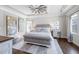 This main bedroom features a decorative rug, a bed, a ceiling fan, and two pieces of wall art at 4590 Gablestone Xing, Hoschton, GA 30548
