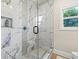 Marble-style tile shower with pebble floor detail and built in shower products niche at 4590 Gablestone Xing, Hoschton, GA 30548