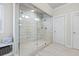 This walk-in shower features a glass surround, built-in niche, and grey horizontal tile at 4590 Gablestone Xing, Hoschton, GA 30548