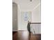 Bright stairway featuring iron railings and hardwood flooring, leading to the upper level at 4590 Gablestone Xing, Hoschton, GA 30548