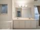 Bright bathroom featuring double sink vanity, large mirror, and tiled tub at 2958 Stonecrest Ln, Lithonia, GA 30038