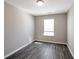 This bedroom features a window and light grey walls, complemented by stylish gray wood-look floors at 402 Whippet St, Union City, GA 30291