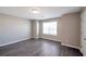 Bright bedroom with neutral walls, gray flooring, a window, and door to hall at 402 Whippet St, Union City, GA 30291