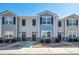 View of townhomes with varying exterior colors, brick foundations, dark shutters, and well-manicured landscaping at 402 Whippet St, Union City, GA 30291